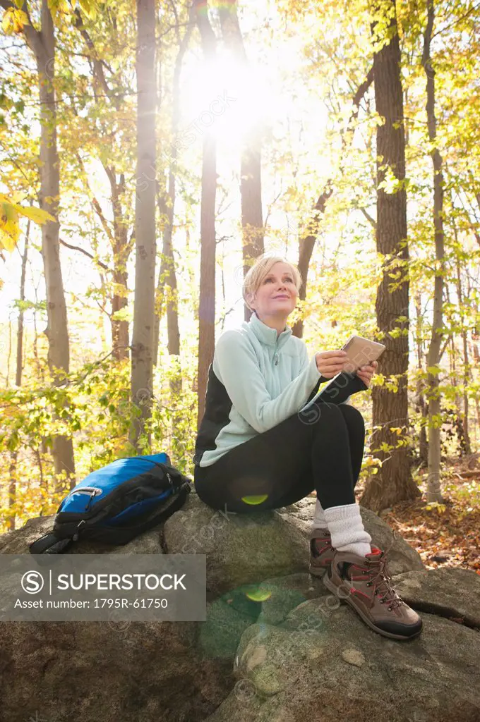 Female hiker using digital tablet in forest