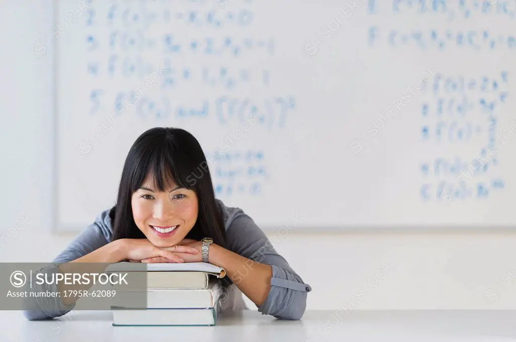 Portrait of smiling woman in front of board with equations
