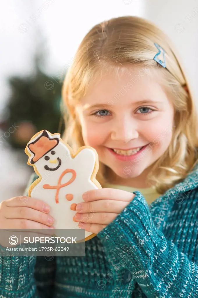Girl 8__9 holding gingerbread cookie