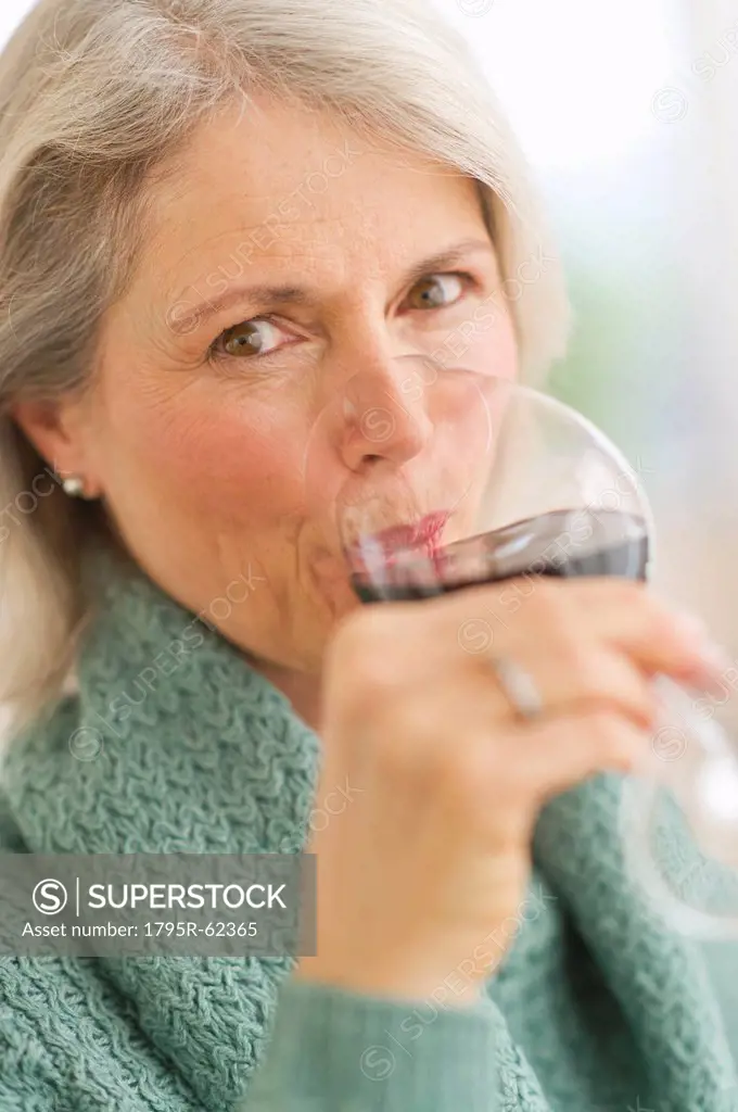 Senior female connoisseur tasting red wine