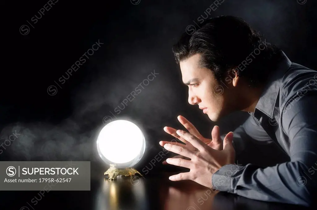 Studio shot of businessman looking at crystal ball