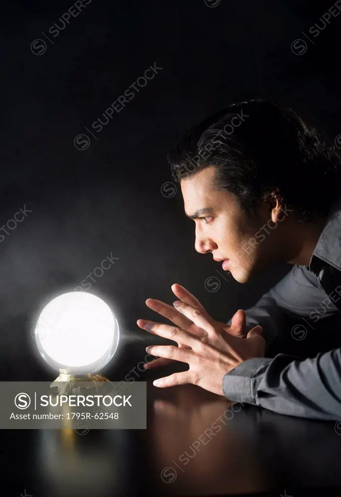 Studio shot of businessman looking at crystal ball