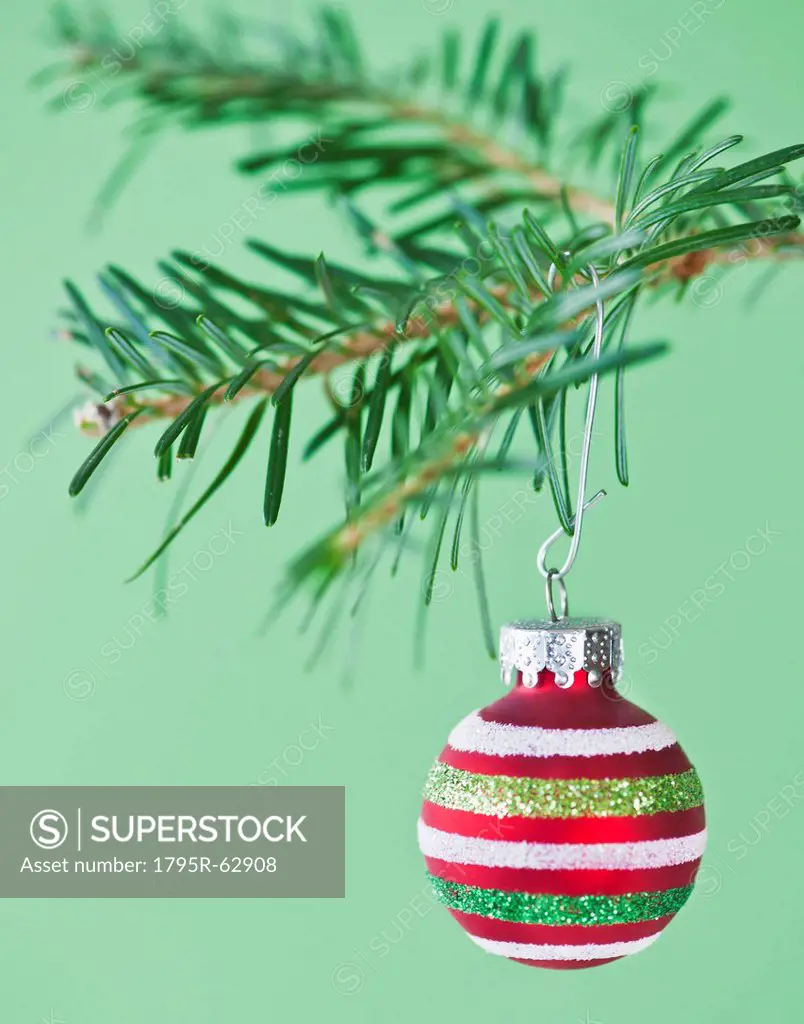 Studio shot of striped Christmas ornament hanging on Christmas tree
