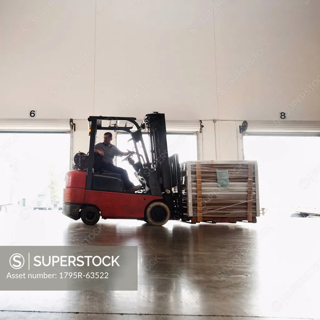 Forklift driver working in warehouse