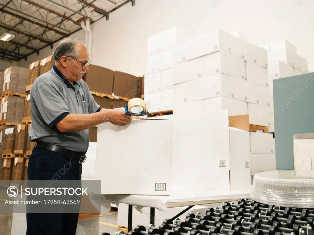 Warehouse worker sealing boxes