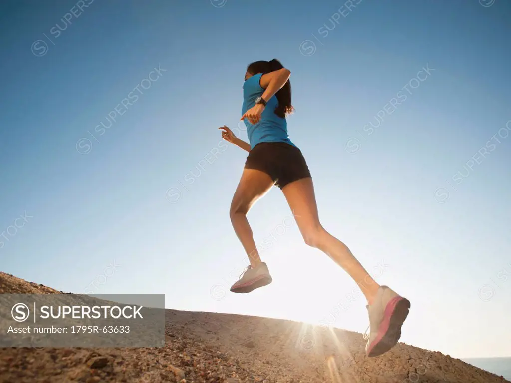 USA, California, San Diego, Woman jogging along sea coast