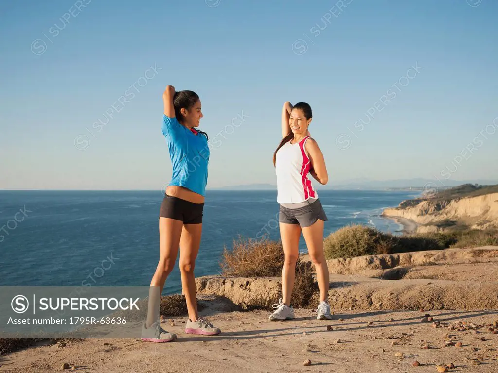 USA, California, San Diego, Two women stretching on beach