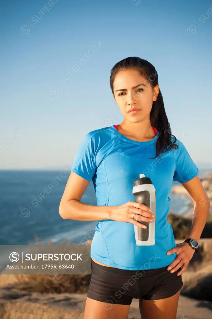 USA, California, San Diego, Portrait of female jogger holding water bottle