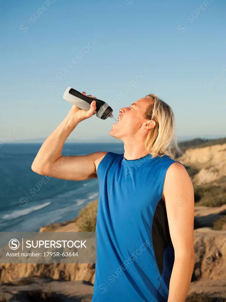 USA, California, San Diego, Male jogger drinking water from bottle