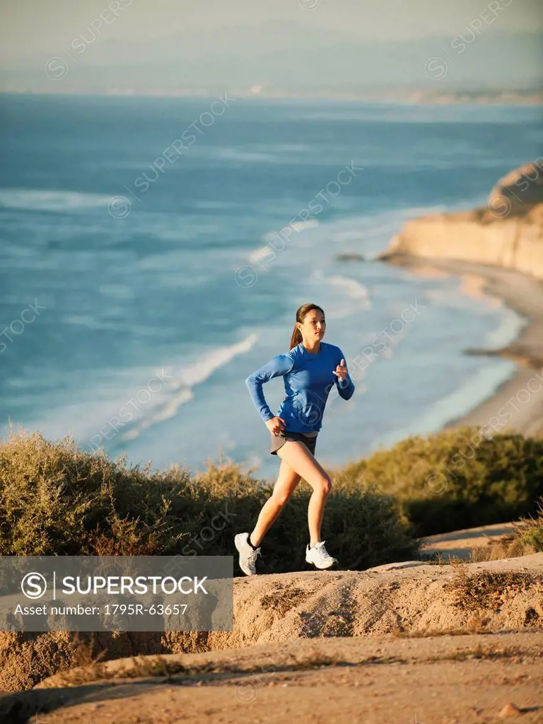 USA, California, San Diego, Woman jogging along sea coast
