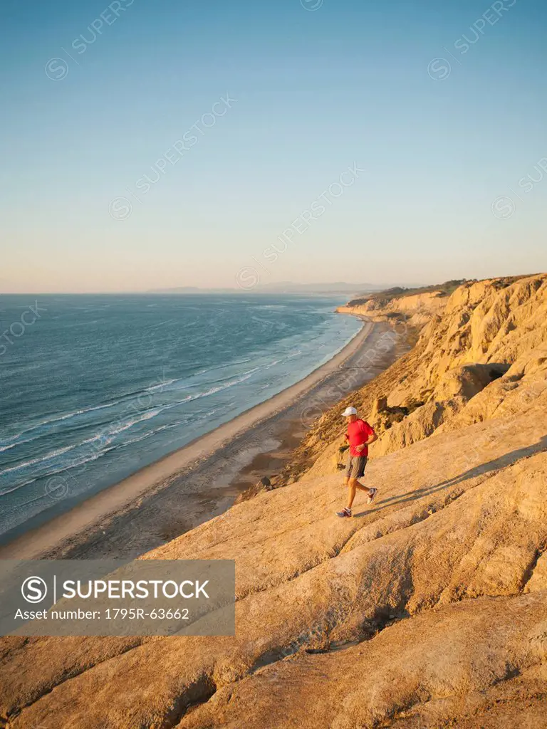 USA, California, San Diego, Man jogging along sea coast