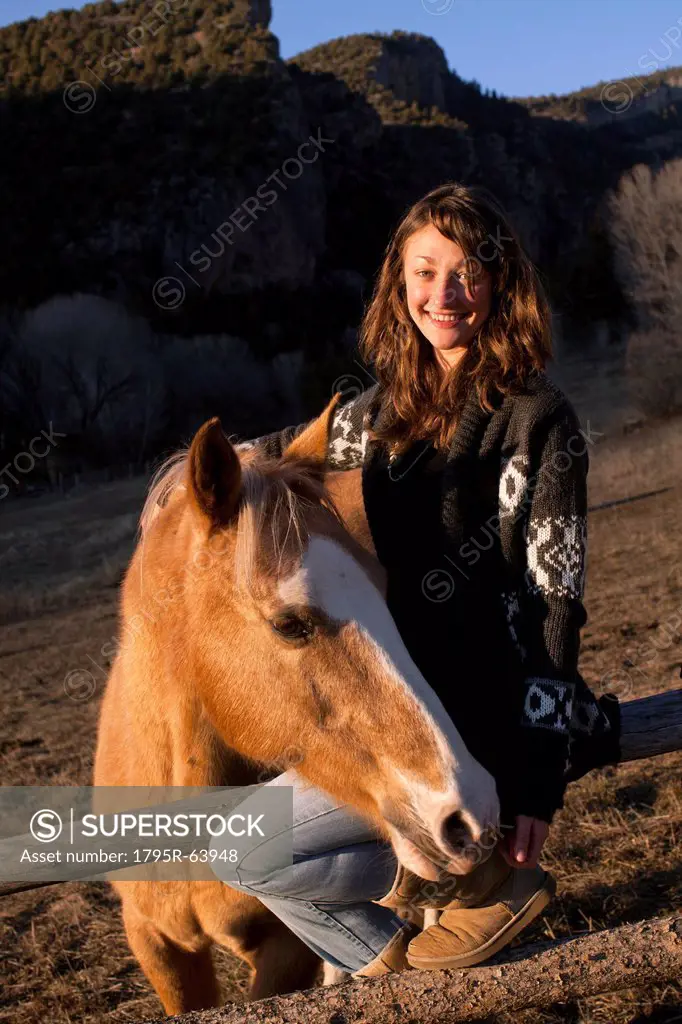 Portrait of young smiling woman with horse