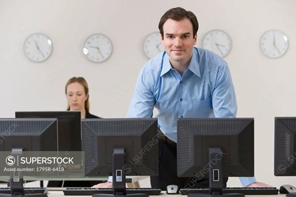 Businessman behind row of computers