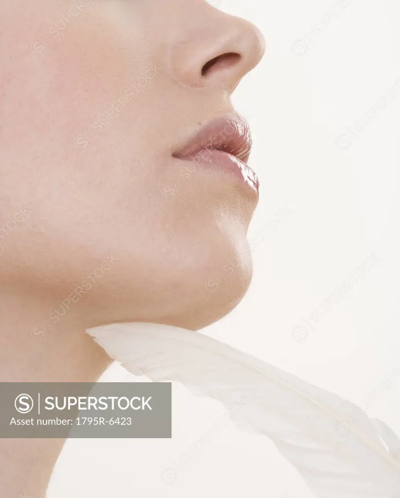Feather touching woman's chin