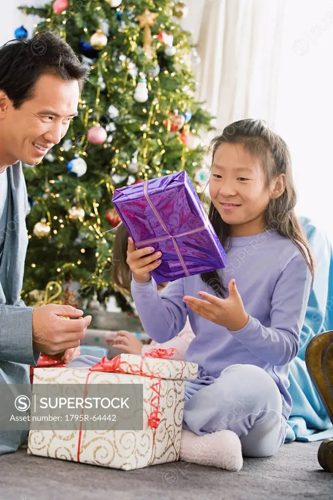Father and daughter unwrapping christmas gifts