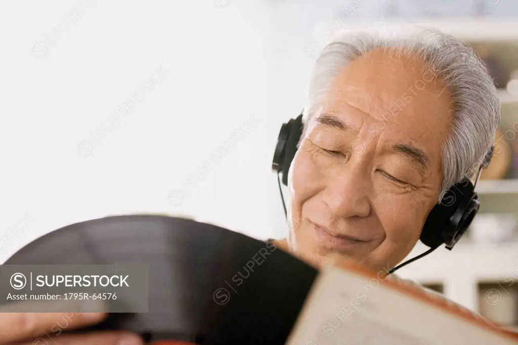 Senior man listening to vinyl record