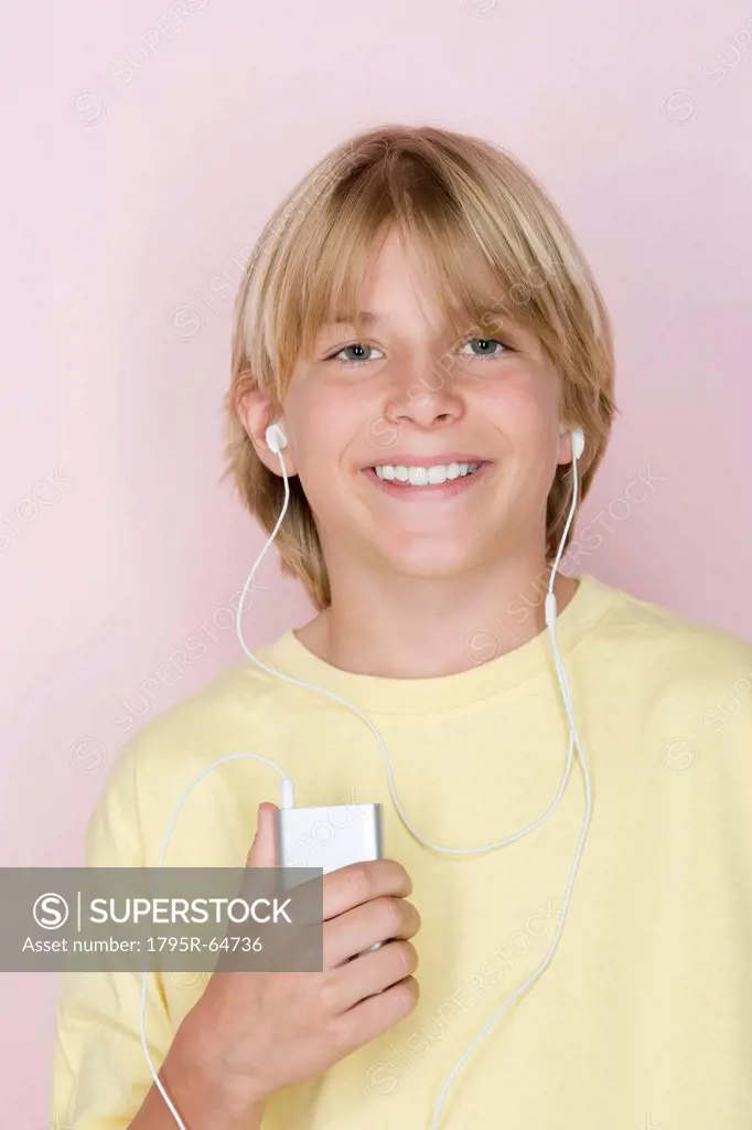 Studio shot portrait of teenage boy with mp3 player, head and shoulders