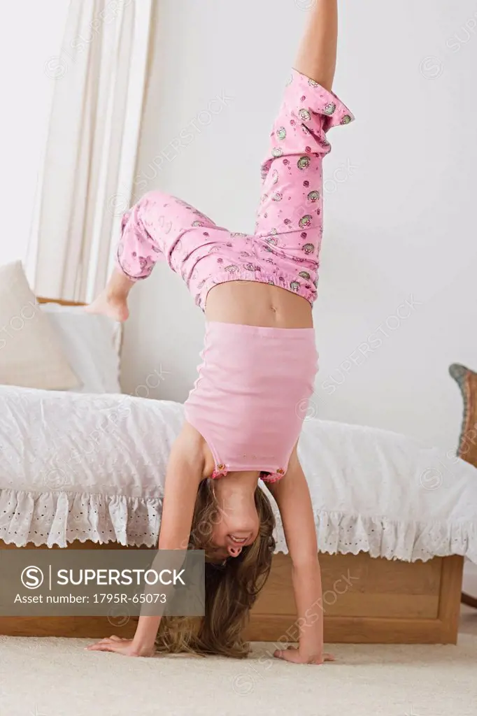Girl 12_13 doing handstand