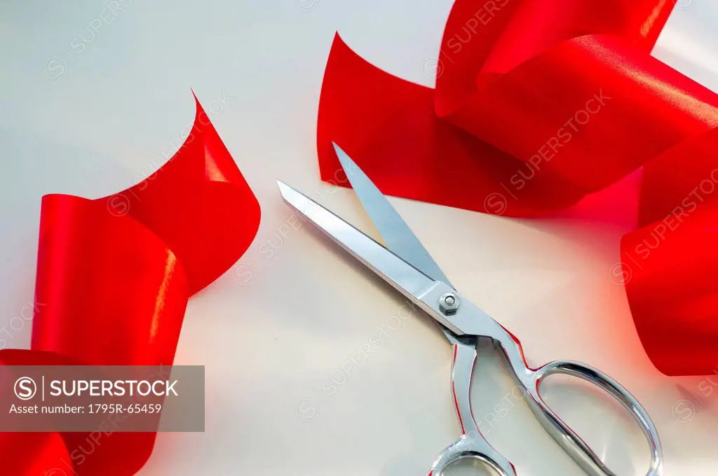 Scissors and red ribbon, studio shot