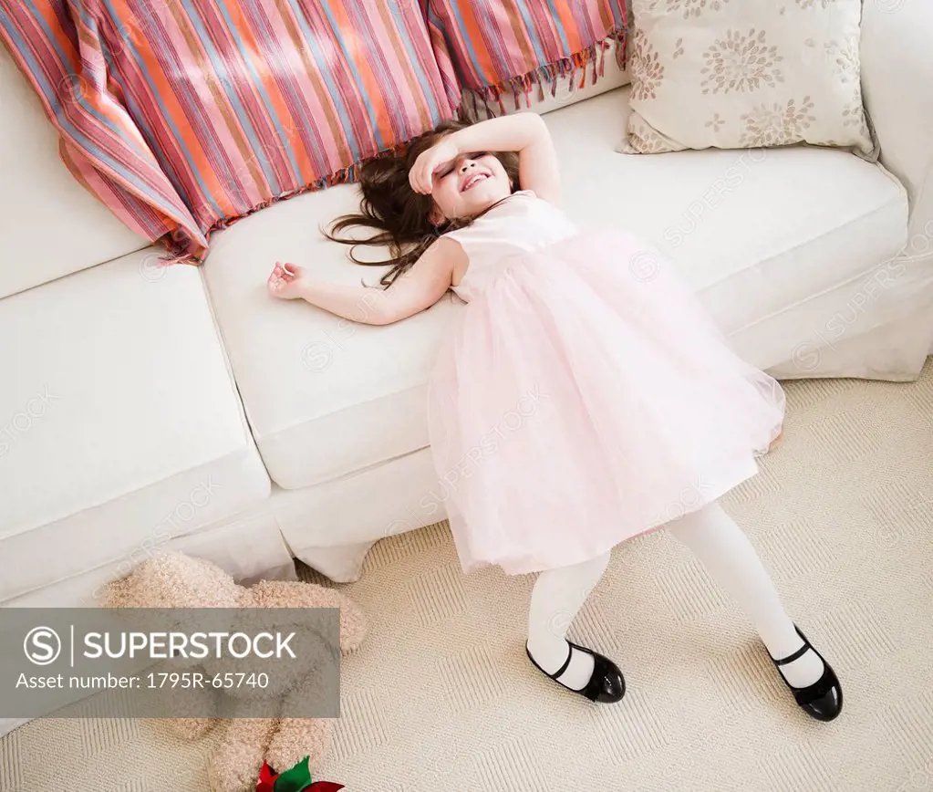 Small girl 4_5 years in tulle dress leaning on sofa