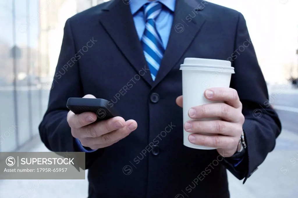 Businessman with smartphone and plastic cup