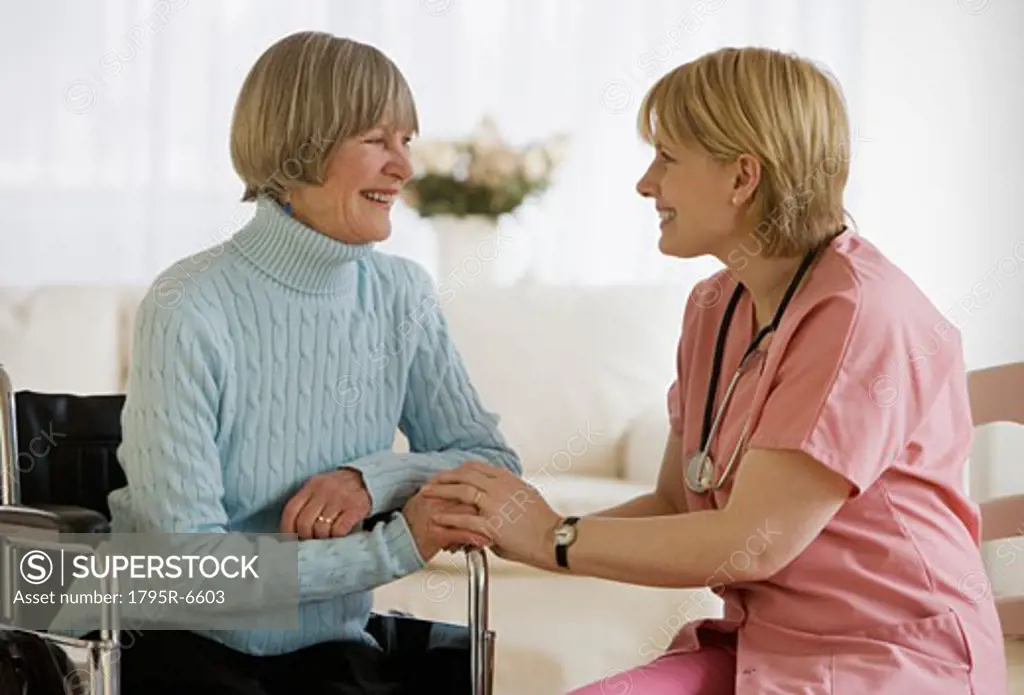 Nurse smiling at senior woman in wheelchair