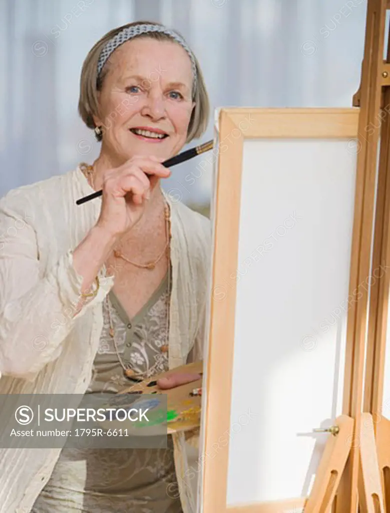 Senior woman painting on easel