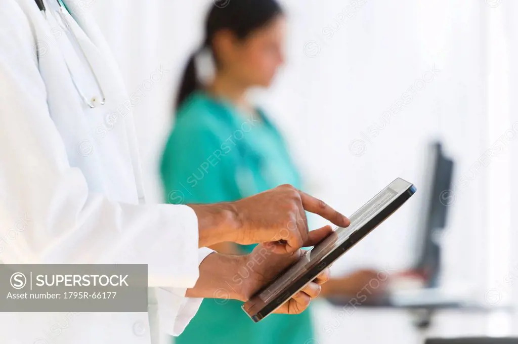 Doctors working on digital tablet and computer