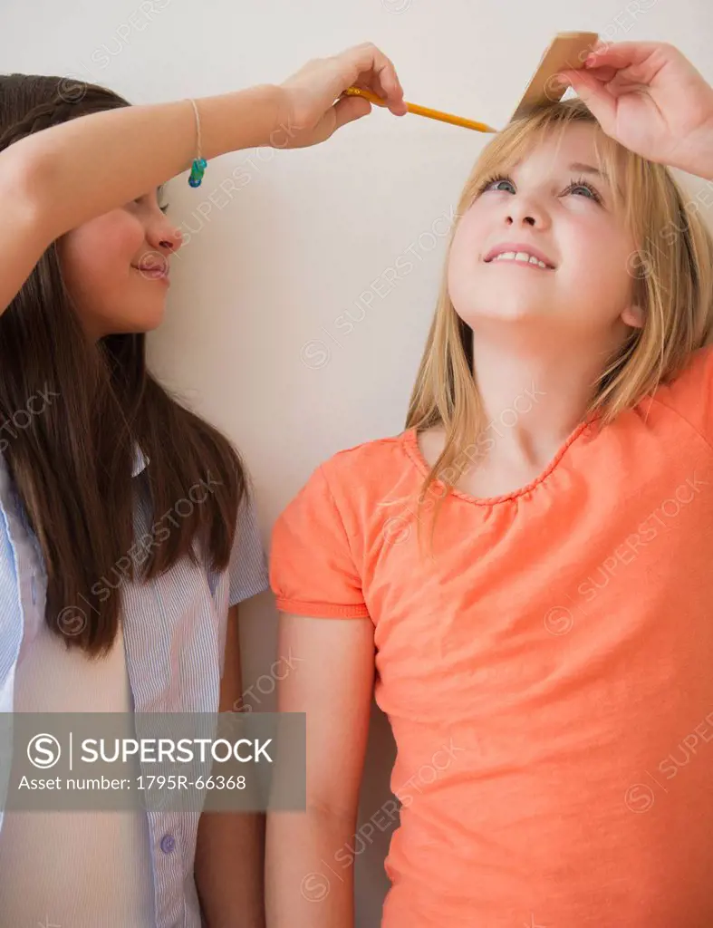 Two girls measuring height