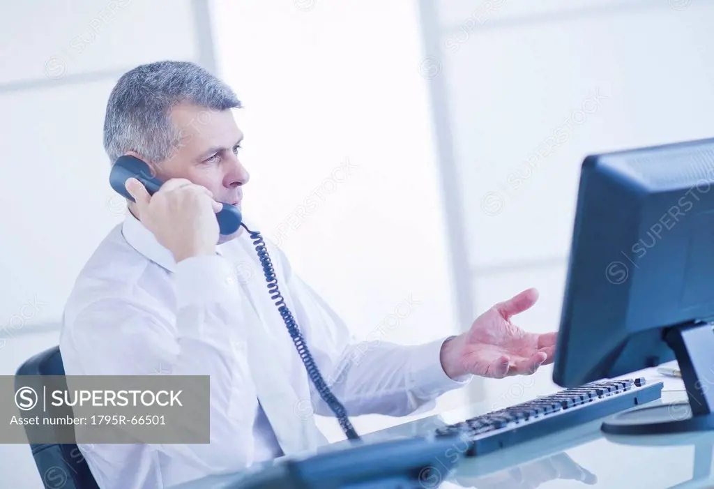 Man sitting in office and talking on landline phone