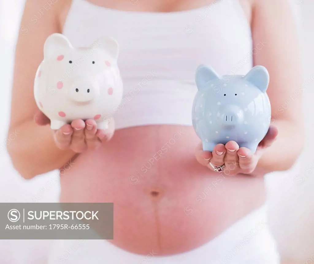 Pregnant woman holding two piggybanks