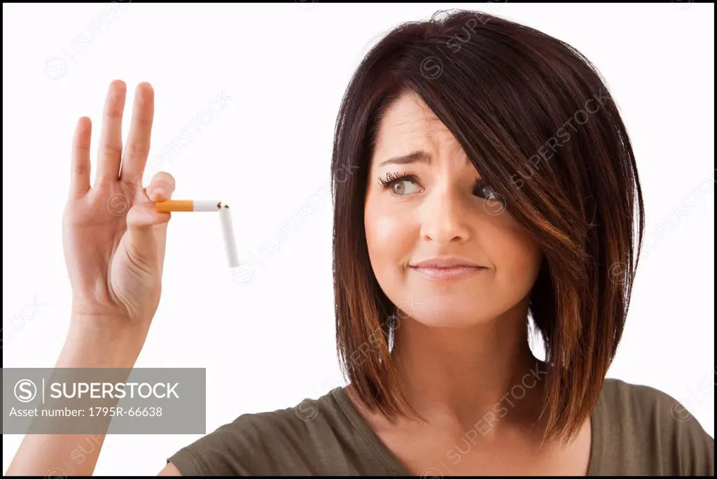 Young woman breaking cigarette