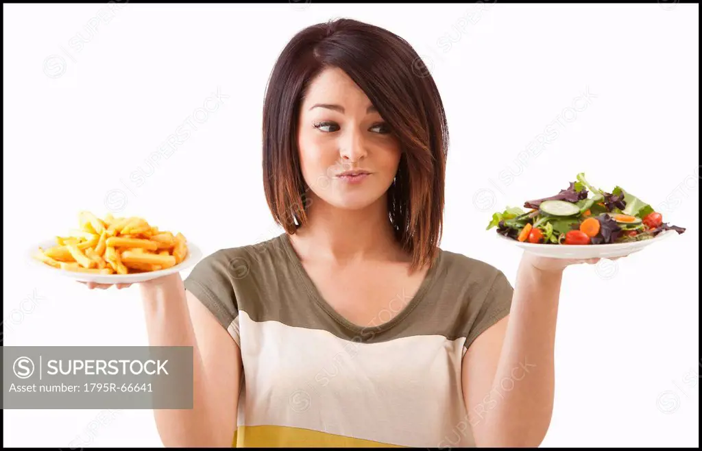 Young woman choosing between healthy and unhealthy food