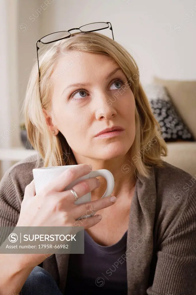 Mid adult woman drinking coffee and looking away