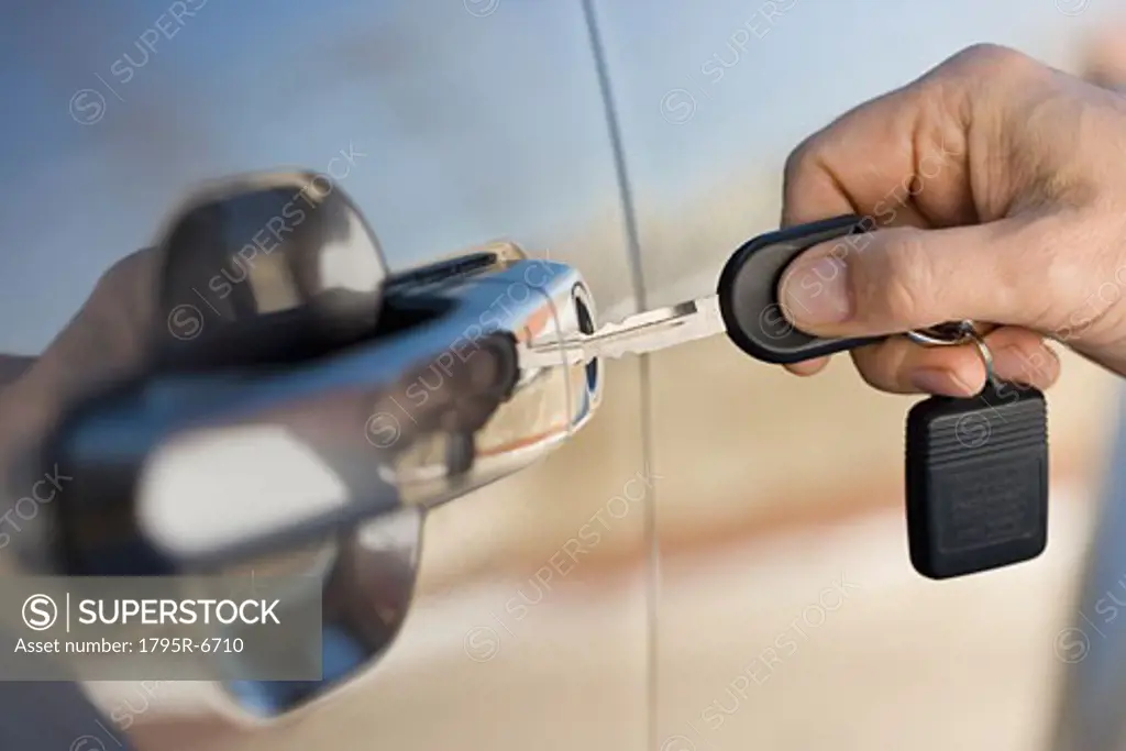 Man putting car key in door