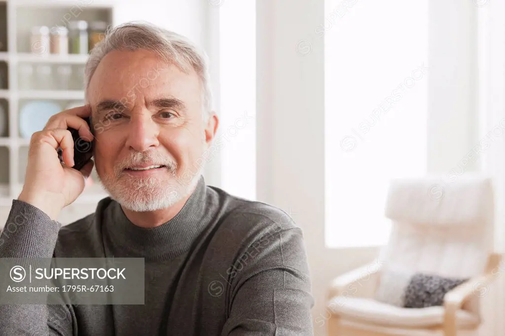 Portrait of smiling senior man talking via mobile