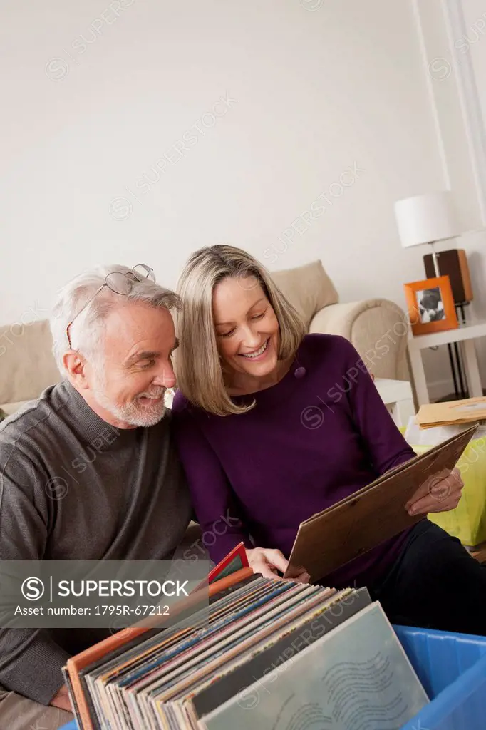 Smiling senior couple looking at vinyl´s in living room