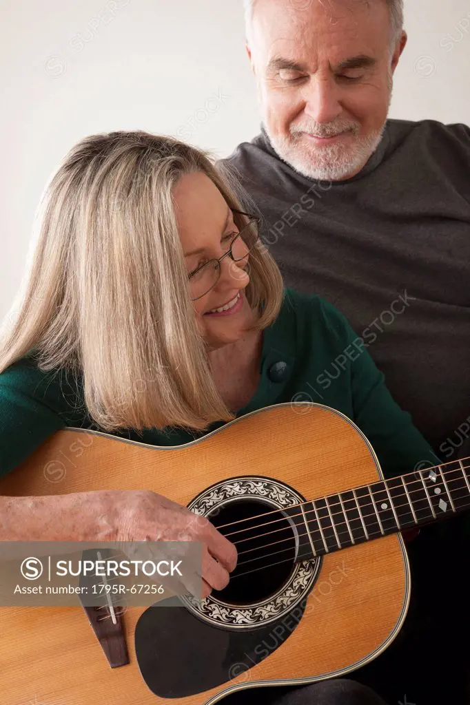 Senior couple, woman playing guitar