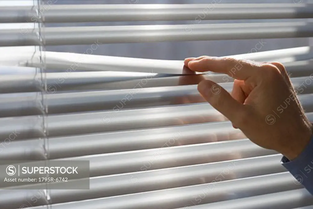 Man looking through blinds