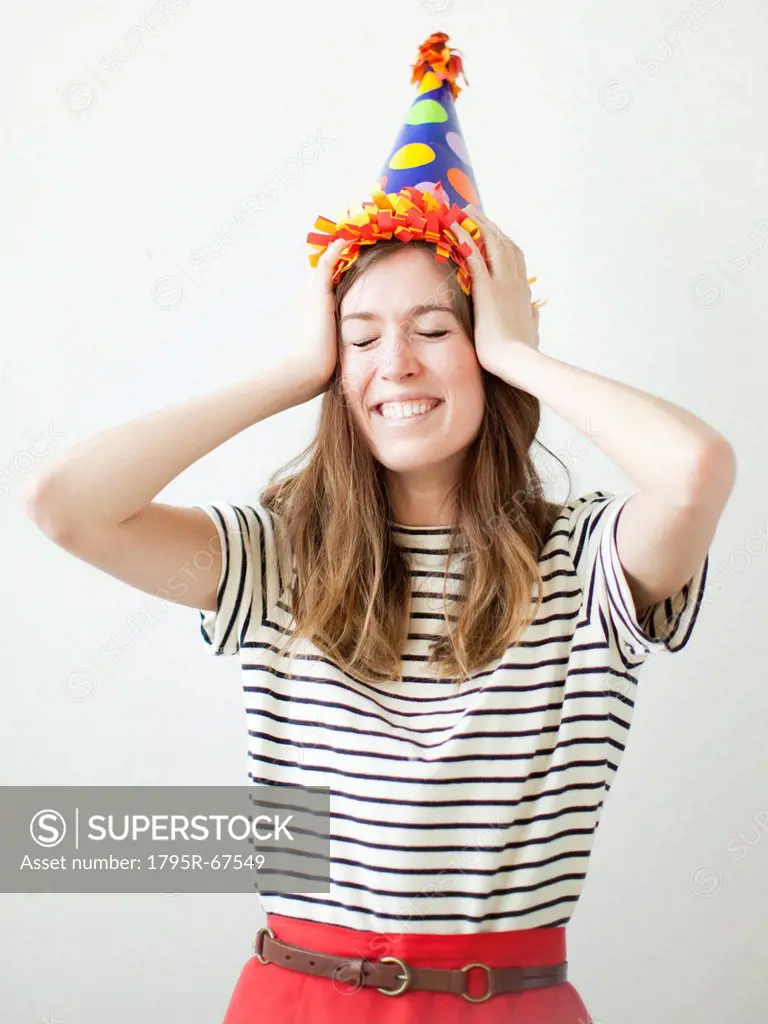 Studio shot of young woman wearing party hat