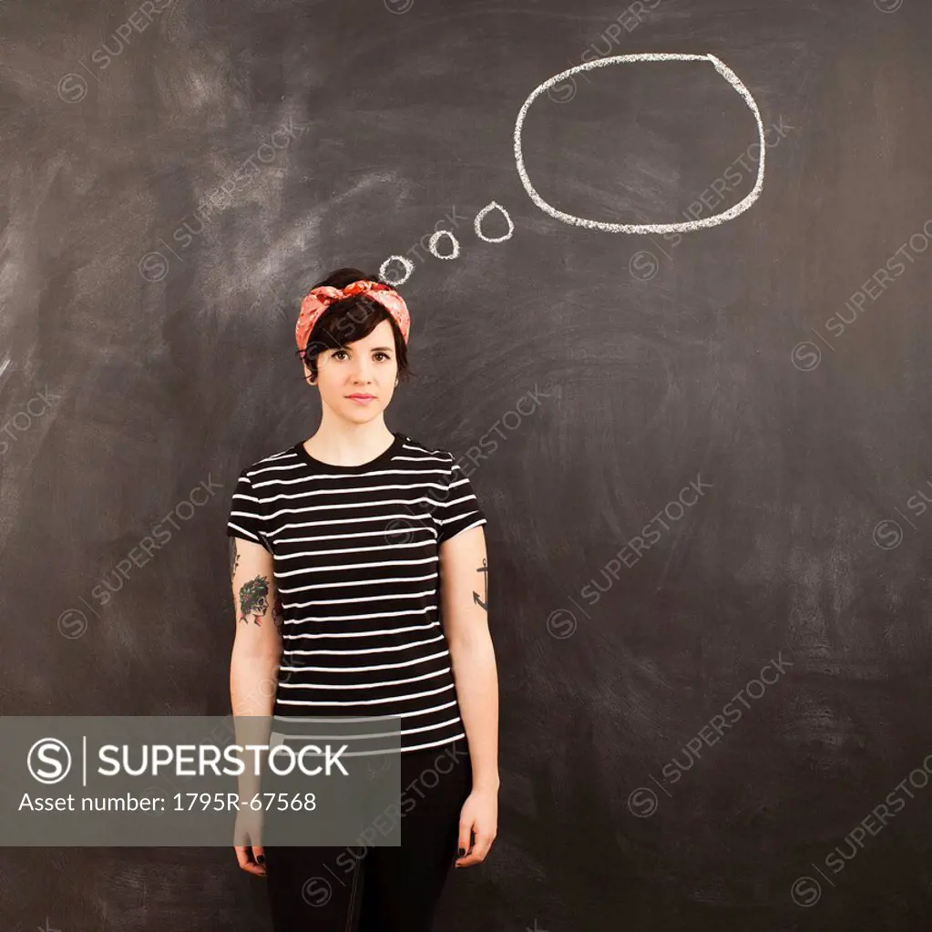 Portrait of young woman in front of blackboard