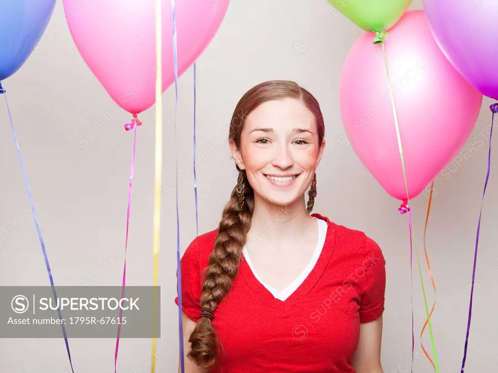 Studio Shot of young woman holding balloons