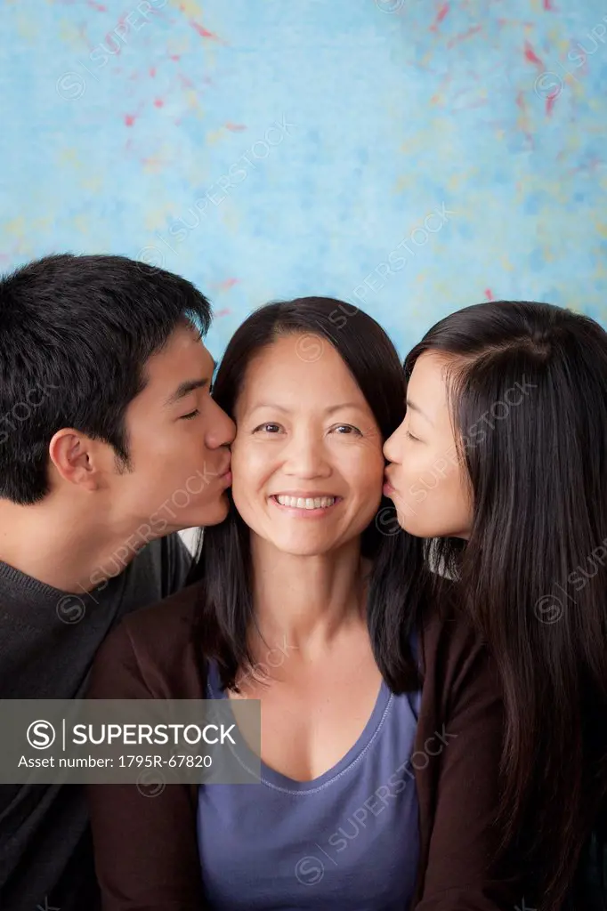 Smiling mother kissed by her children