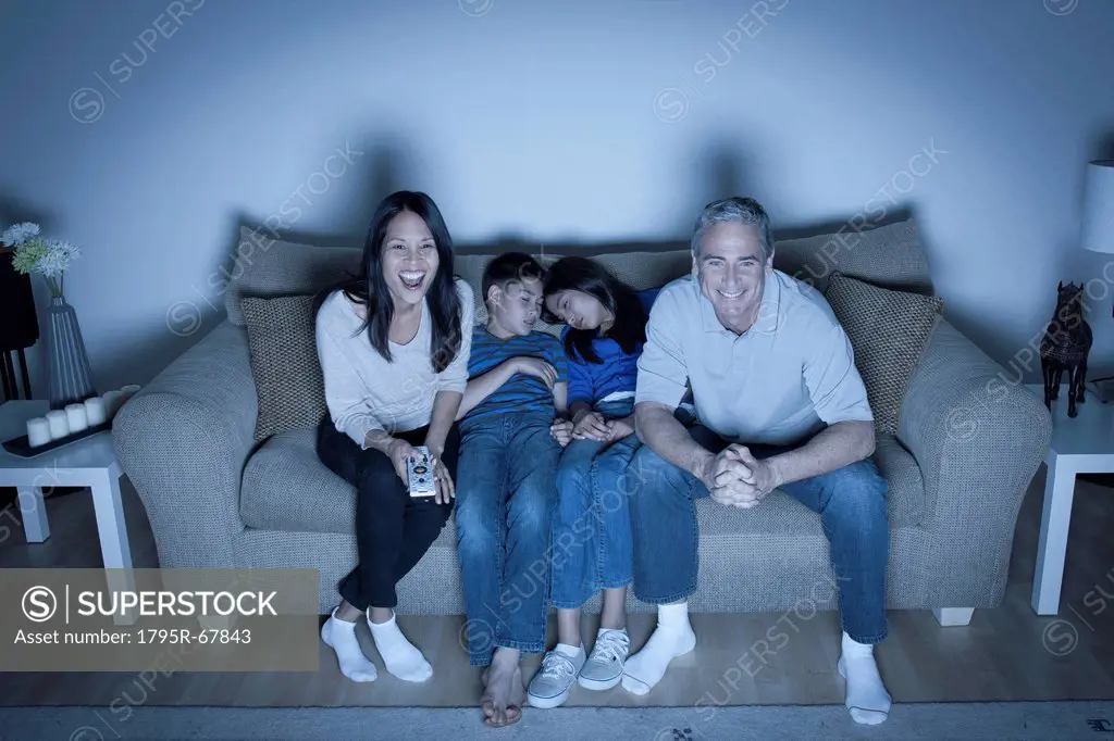 Family sitting on sofa and watching television