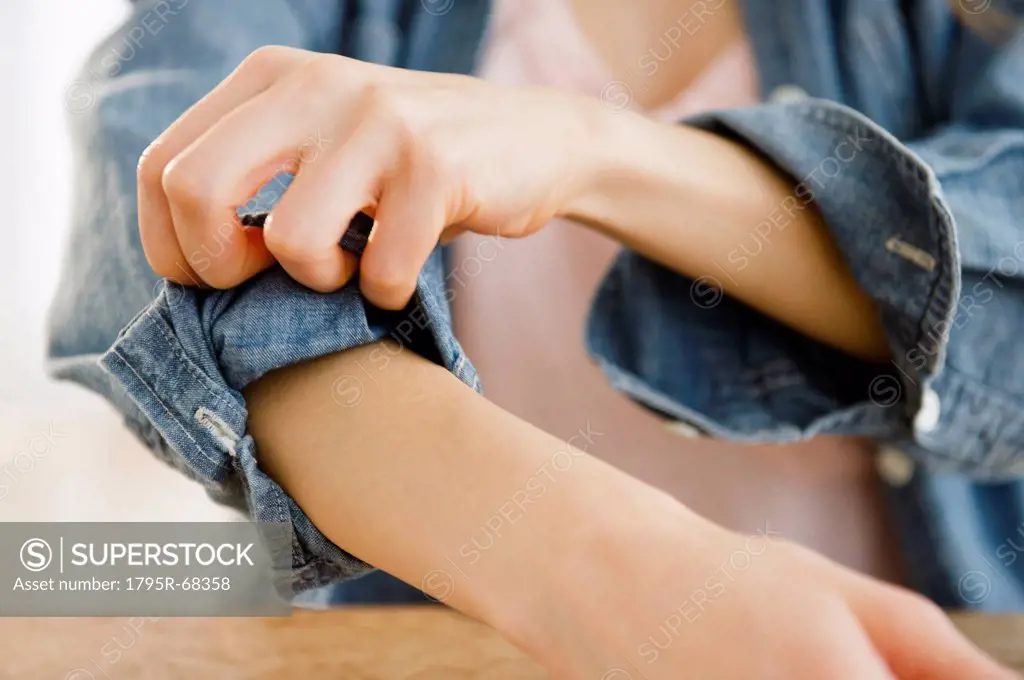 Woman rolling up sleeve
