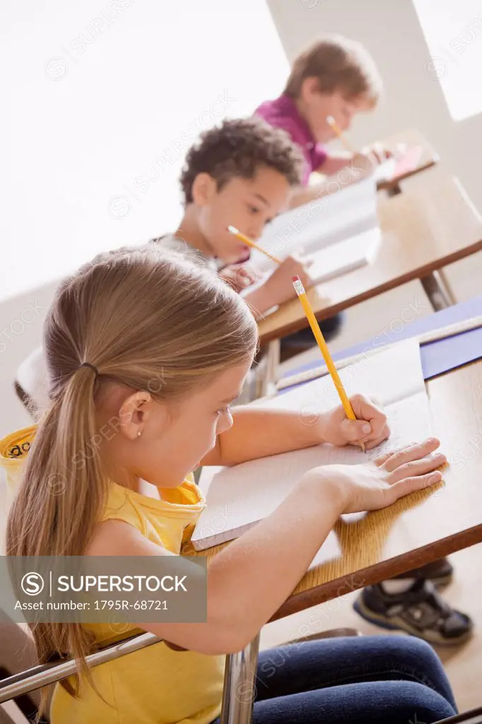 Schoolchildren focused on writing in classroom