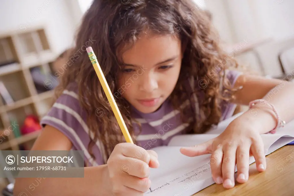 Schoolgirl focused on writing in classroom