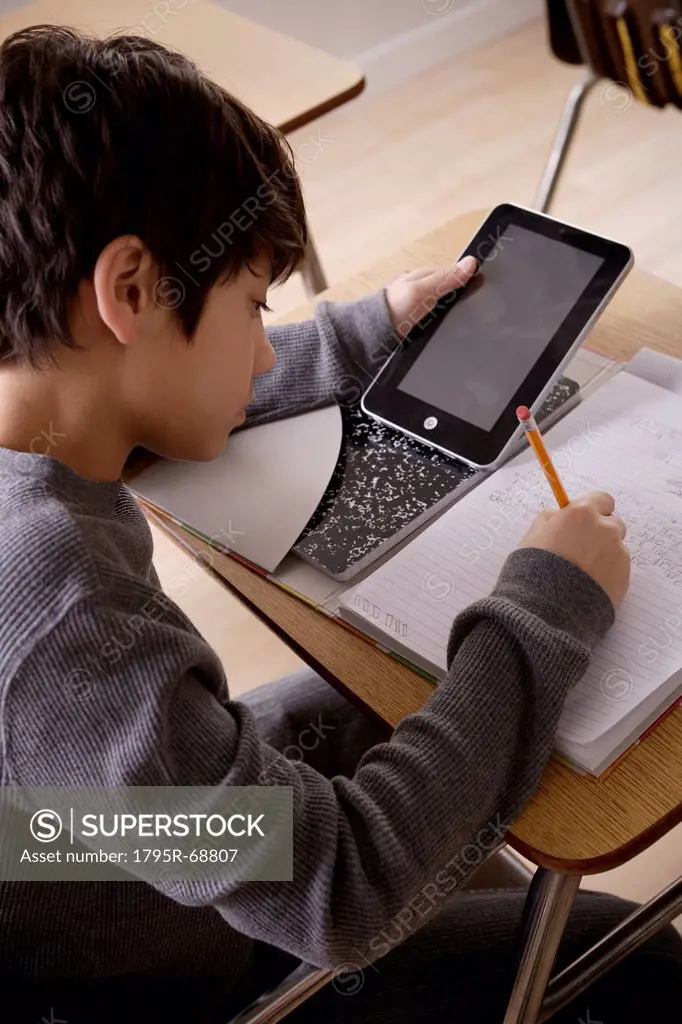 Schoolboy 12_13 with digital tablet at school