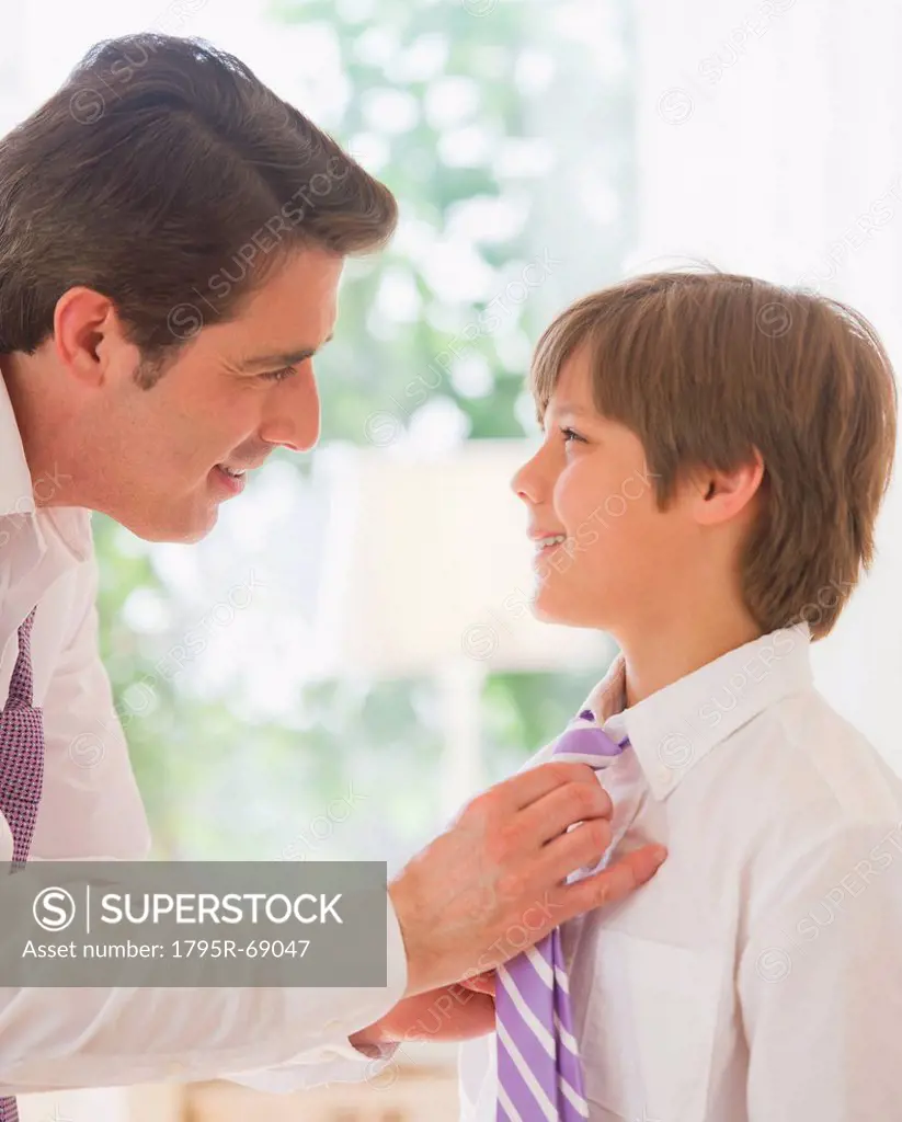 Father helping son 10_11 years to tie tie