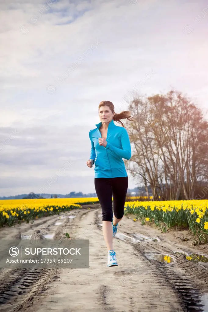 USA, Washington, Skagit Valley, Woman running in rural area